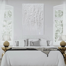 Modern bedroom with a bed, abstract painting, and side tables.