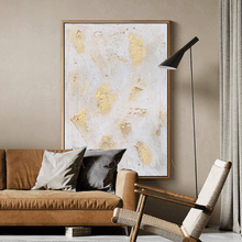 Living room with a brown sofa, armchair, and abstract art on the wall.