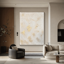 Modern living room with minimalist white abstract art on the wall, dark brown armchair, and beige sofa.