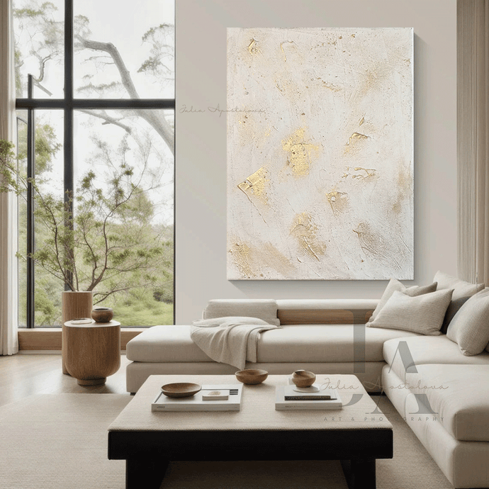 Modern living room with a large white gold abstract painting on the wall, a sectional sofa, and a coffee table.