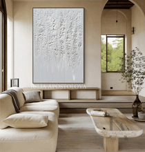 Modern living room with a large abstract painting, beige sofa, and wooden coffee table.