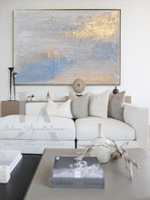 Modern living room with a large abstract painting above a white sofa.