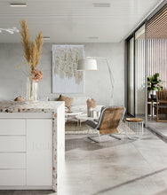 Modern living room with a white gold wabi sabi art, white sofa, wooden chair, and decorative elements.