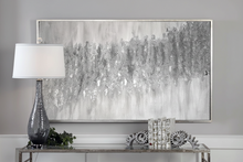 Decorative console table with lamp, books, and framed minimalist white silver glitter abstract painting in a room.