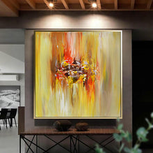 A large framed abstract canvas painting with bold yellow, orange, red, and white brushstrokes, displayed on a dark wall above a console table in a modern interior setting.