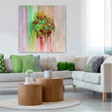 A colorful abstract canvas wall art print featuring green, pink, and red brushstrokes, displayed in a modern living room setting above a light beige sectional sofa with green and purple accent pillows.