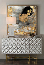 A contemporary abstract gold leaf canvas art hanging on a wall over a white modern cadenza, with a focus on the artwork featuring gold leaf and metallic accents.