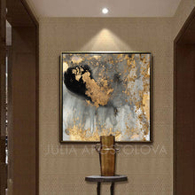 A contemporary abstract gold leaf canvas art featuring gray, black and metallic accents.